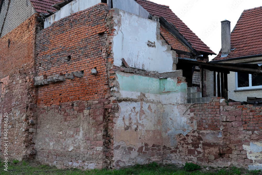 ruined house with empty windows, broken brick, cracks on the wall of a dilapidated building, the concept of ruin of people, business collapse due to Social problems, poverty, Low income, Urban decay
