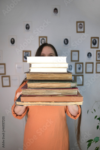 young european woman with long hair holding old thick photo albums, family archive, books, concept of genialogy, memory of ancestors, family tree, childhood memories photo