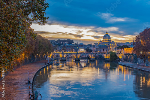 Twilight beacons on the Ponte Umberto I bridge overlooking St. Peter's Cathedral and Vatican city. 