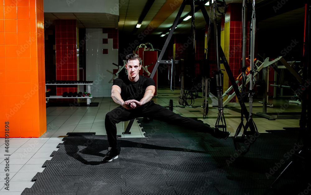 Obraz premium guy doing exercises on TRX loops in the gym