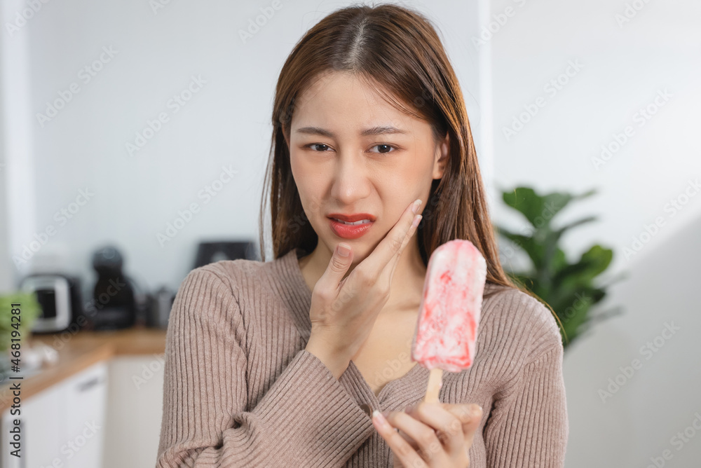 Asian Woman touching her chin feeling sensitive teeth when eating an ice cream. Have a gum and oral problem. Asian Woman touching her chin feeling sensitive teeth when eating an ice cream. Have a gum and oral problem.