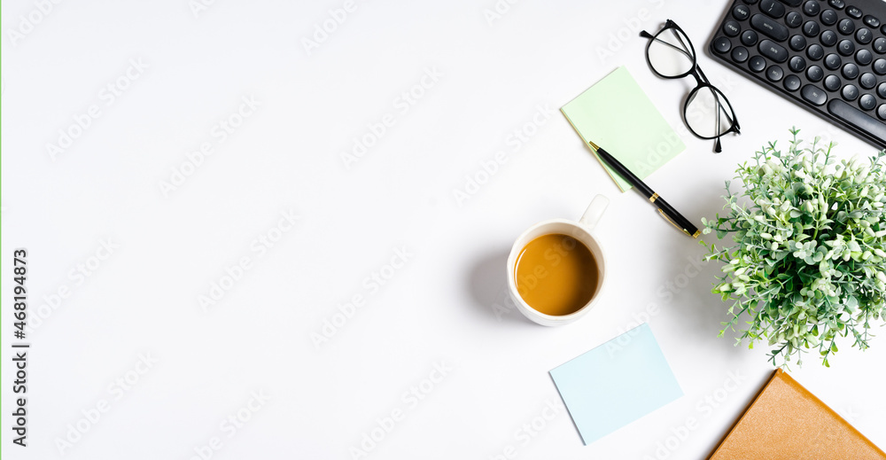 Top view of coffee, book, notebook, pen, keyboard, phone on white background Top view of coffee, book, notebook, pen, keyboard, phone on white background