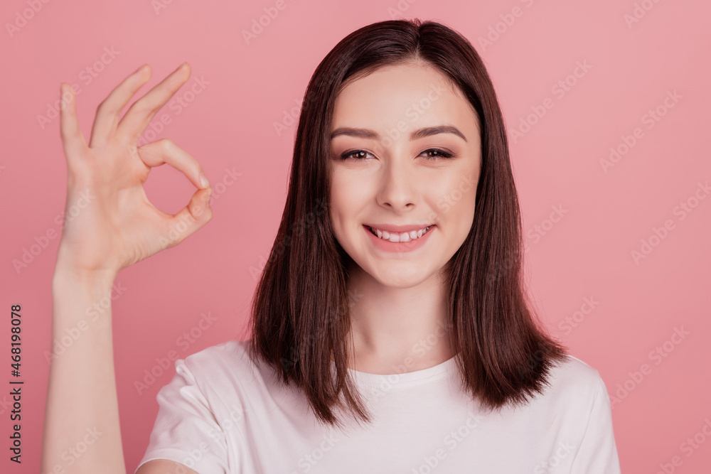 Photo of young attractive woman happy positive smile show okay alright sign great isolated over pink color background Photo of young attractive woman happy positive smile show okay alright sign great isolated over pink color background