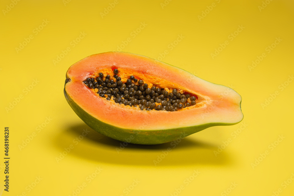 Papaya fruit on a yellow background. Tropical fruit. Papaya fruit on a yellow background. Tropical fruit.