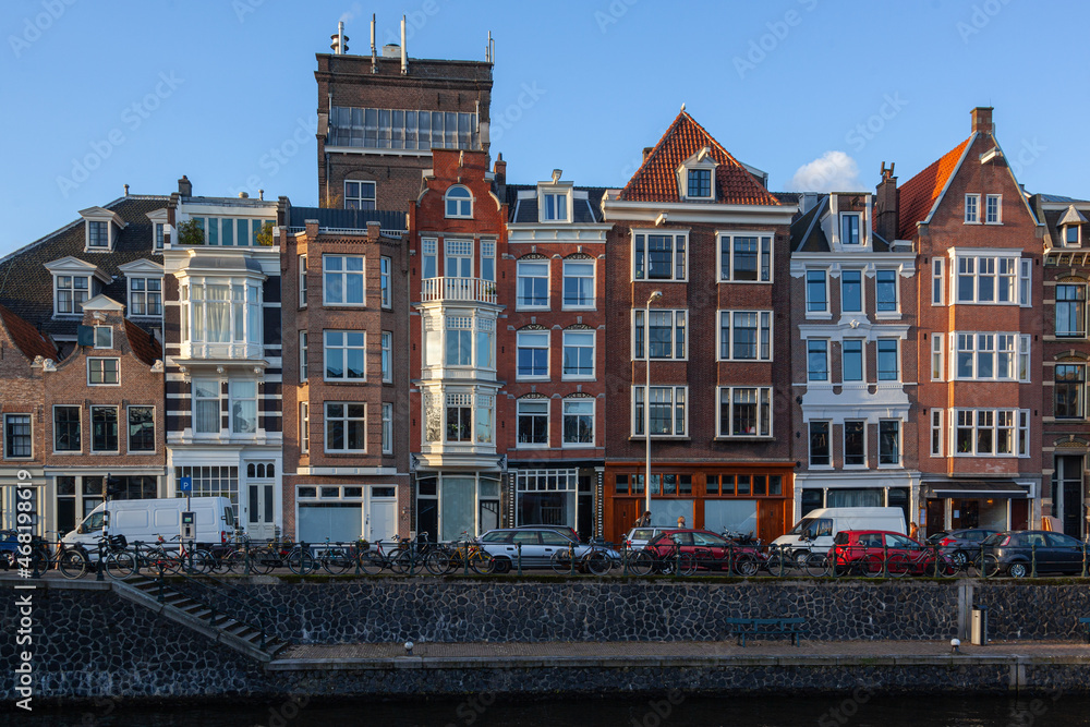 Picturesque facades of traditional houses along the canal in the old town of Amsterdam , Netherlands.