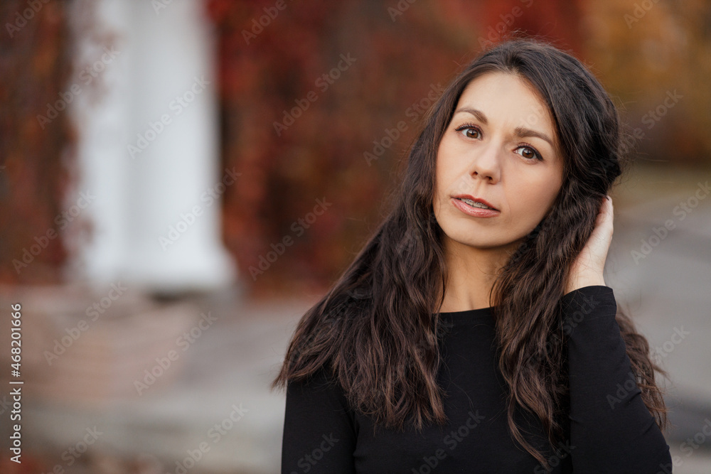 Close up Portrait of a young brunette woman against the background of a burgundy autumn landscape Close up Portrait of a young brunette woman against the background of a burgundy autumn landscape