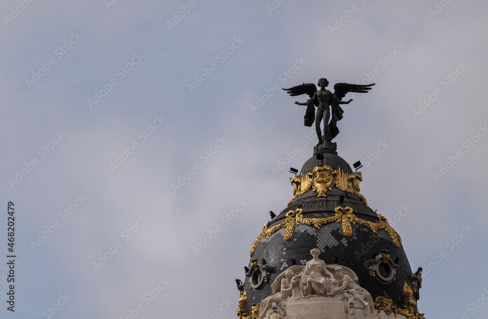 Angel statue on tower of Metropolis building in center of Madrid, Spain, against sky. Angel statue on tower of Metropolis building in center of Madrid, Spain, against sky.