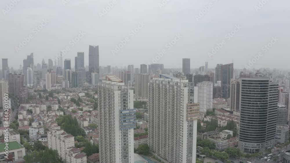 Drone flying sideways over a populous zone in Shanghai, China. Residential big and medium size visible, and financial business skyscrapers in background. High city pollution - contamination. Drone flying sideways over a populous zone in Shanghai, China. Residential big and medium size visible, and financial business skyscrapers in background. High city pollution - contamination.