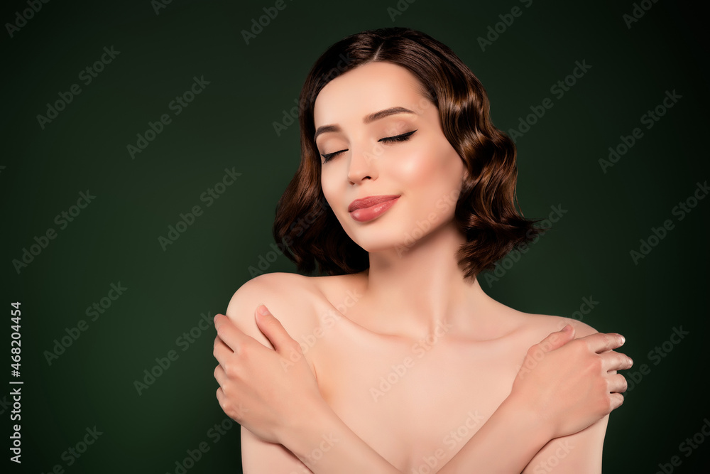 Photo of good mood beautiful attractive female hug embrace herself self-esteem isolated on green color background Photo of good mood beautiful attractive female hug embrace herself self-esteem isolated on green color background