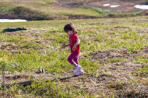 The extreme north, Yamal, the past of Nenets people, the dwelling of the peoples of the north, a girl playing near the yurts in the tundra photo