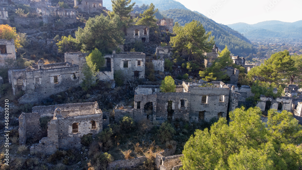 Historical Lycian village of Kayakoy, Fethiye, Mugla, Turkey. Drone aerial shot from above of the Ghost Town Kayakoy. Greek Village. Evening moody warm sun of the ancient city of stone