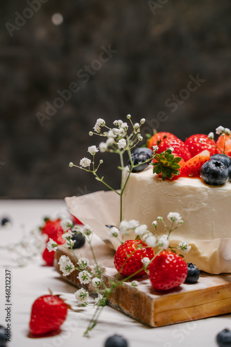 Beautiful strawberry cake decorated with blueberries on a white background