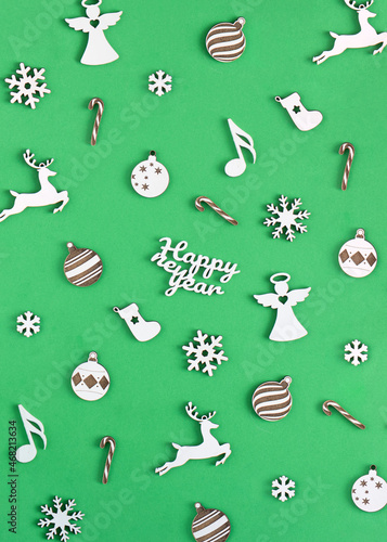 Minimal new year concept. Creative layout made with snowflake, sock, angel, note, reindeer, lollipop and ball. Green background.