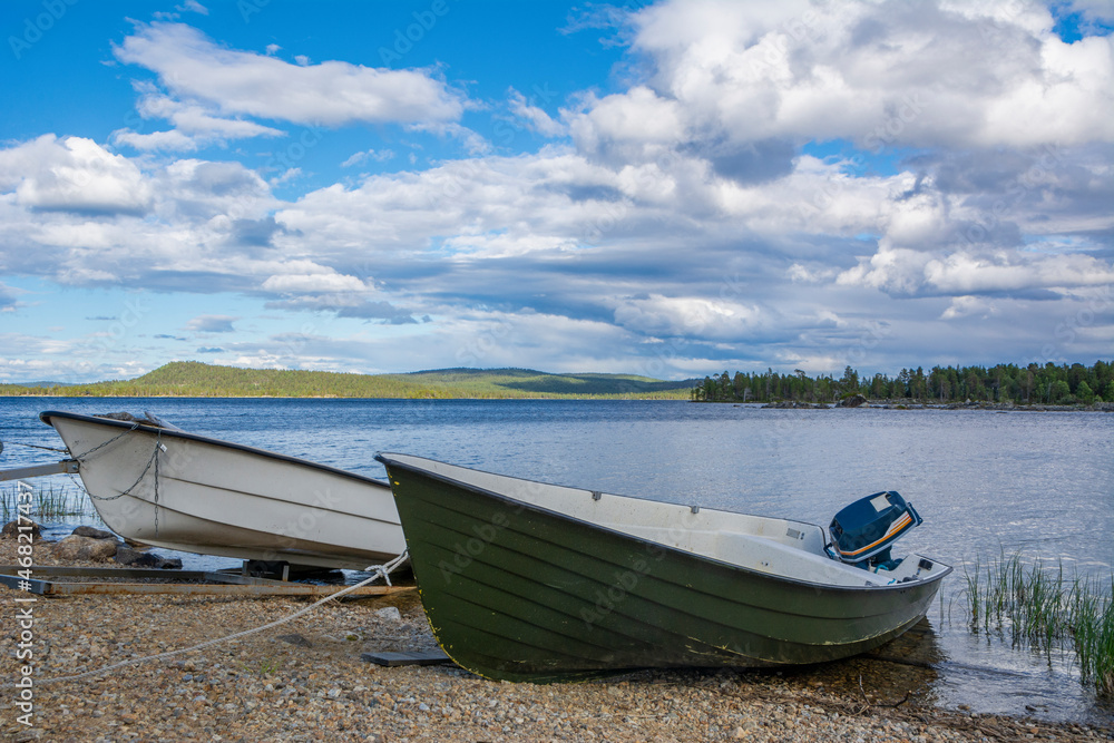 Boats on the shore of The Lake Inari in summer, Lapland, Finland Boats on the shore of The Lake Inari in summer, Lapland, Finland