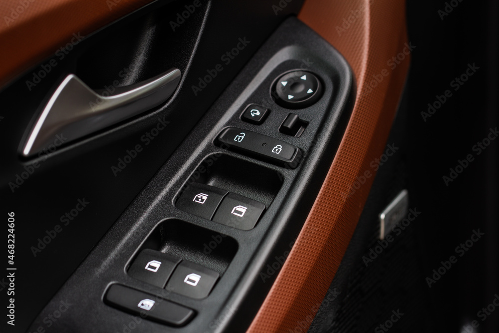 Close up view of button controlling window in modern car interior. Vehicle interior detail. Door handle with windows controls Close up view of button controlling window in modern car interior. Vehicle interior detail. Door handle with windows controls