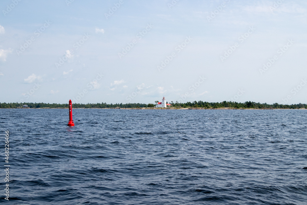 Red channel marker and Byng Inlet Range Front Lighthouse on Georgian Bay, Ontario, Canada