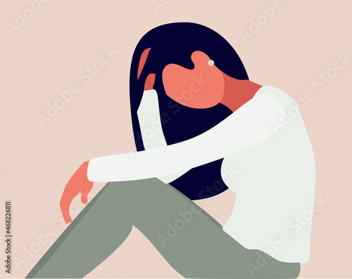 A young sad girl is sitting and unhappily holding her head with her hand. A woman with confused thoughts in her head.