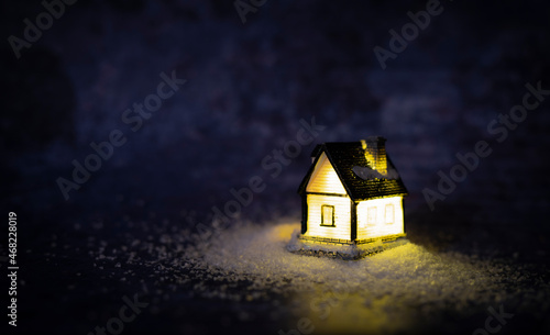 Flashlight in the form of a house on artificial snow. Dark Christmas background with place for text. High quality photo