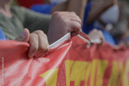 Mani che tengono uno striscione durante una manifestrazione di protesta photo
