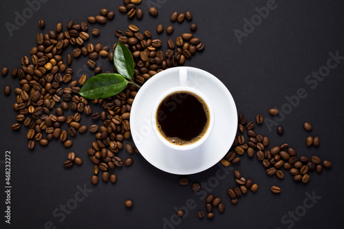Top view of coffee cup and coffee beans on the black background.  Close-up.