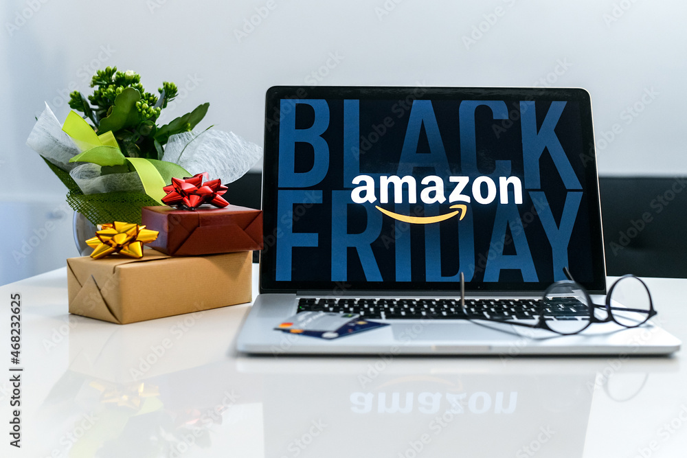 Purchasing Christmas gift in the Amazon online shop the black friday. Logo  on the laptop monitor. Purchase of Christmas gifts. E-commerce, tech, shopping  online concept. Milan, Italy - November 2021 Stock Photo