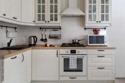 White modern kitchen furniture: equipped counter with appliances, stright view