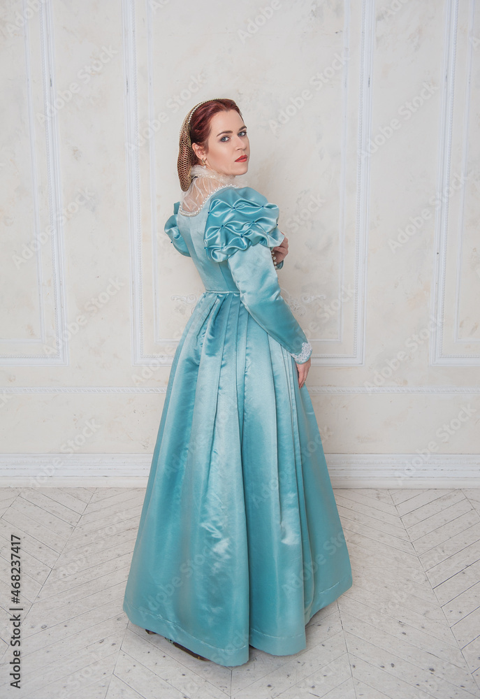 Beautiful young woman in medieval style dress turning