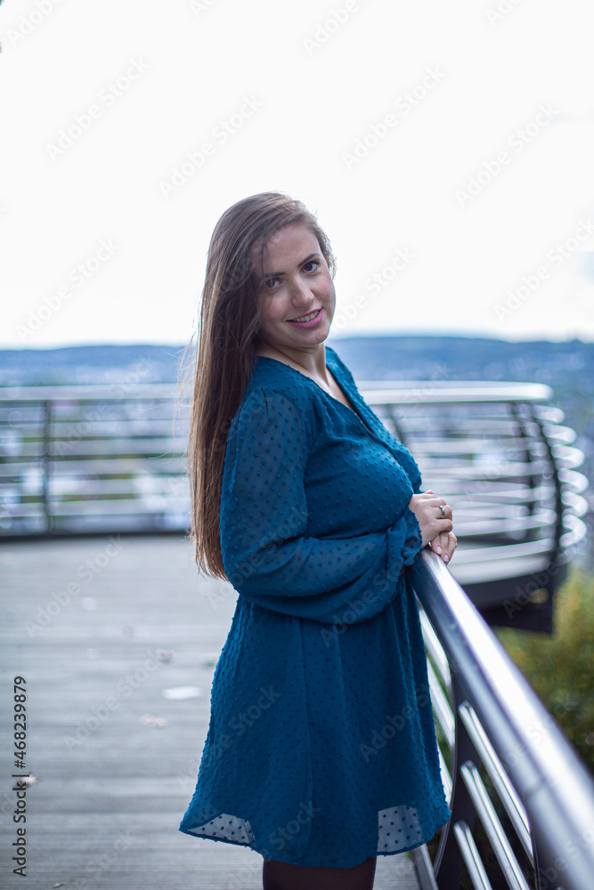 White young european woman with dark hair outside in blue dress