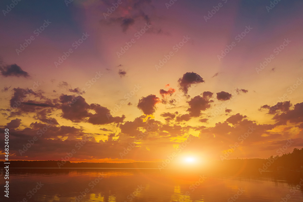 Orange pastel sky in the background. Beautiful romantic dreamy clouds. At sunset. Water reflection. High quality photo
