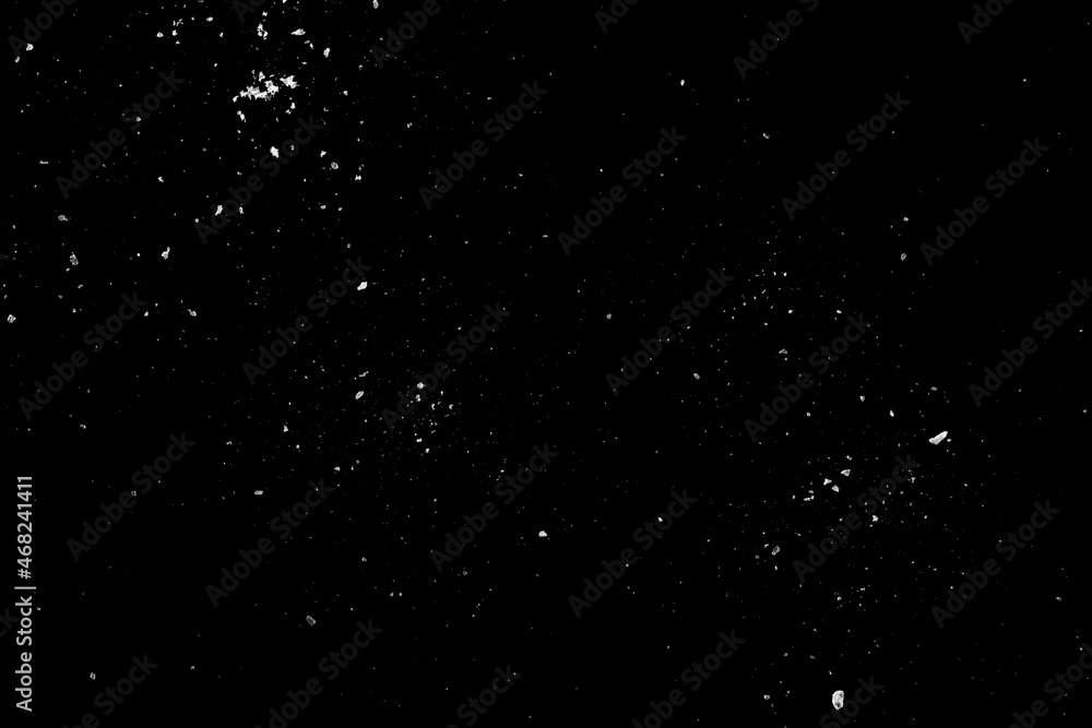 Obraz premium Sea salt is scattered on the black surface of the table.