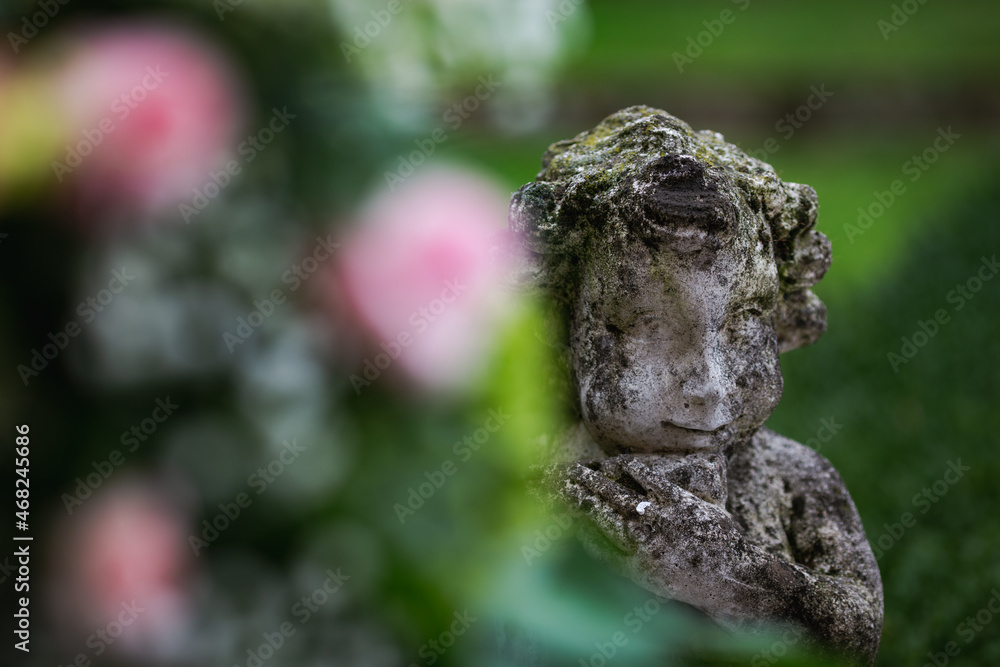 Decorative old Stone art figure of child outdoors in park