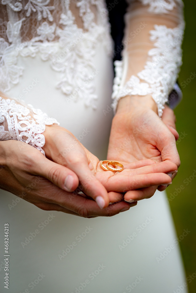 Female and male hands together hold and show in palm wedding rings Female and male hands together hold and show in palm wedding rings