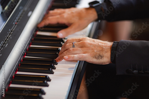 Side view pianist hands play piano keys in formal celebration event indoors