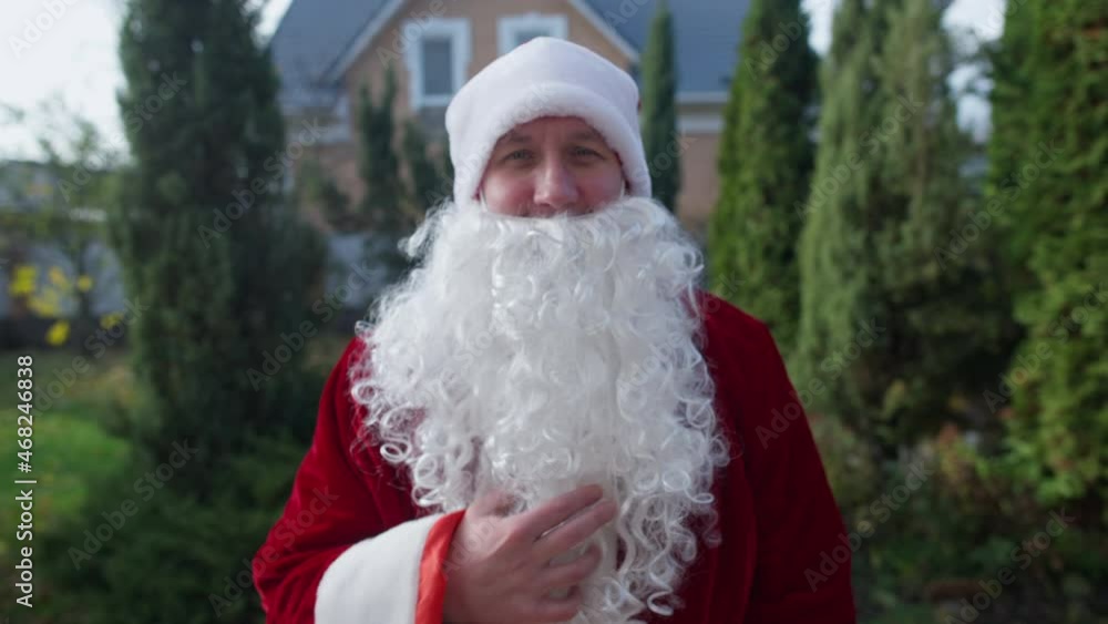 POV Santa Clause giving present to unrecognizable person standing on backyard porch. Front view man in red costume with white beard congratulating on New Year. Personal point of view, live camera POV Santa Clause giving present to unrecognizable person standing on backyard porch. Front view man in red costume with white beard congratulating on New Year. Personal point of view, live camera