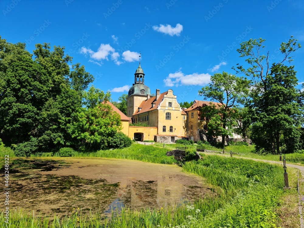 Beautiful Latvian Lielstraupe castle among green trees on a sunny summer day in 2021