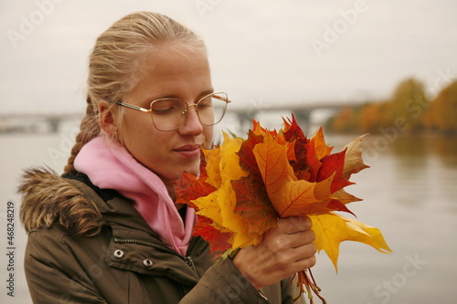 Girl holding colorful autumn leaves in her hands