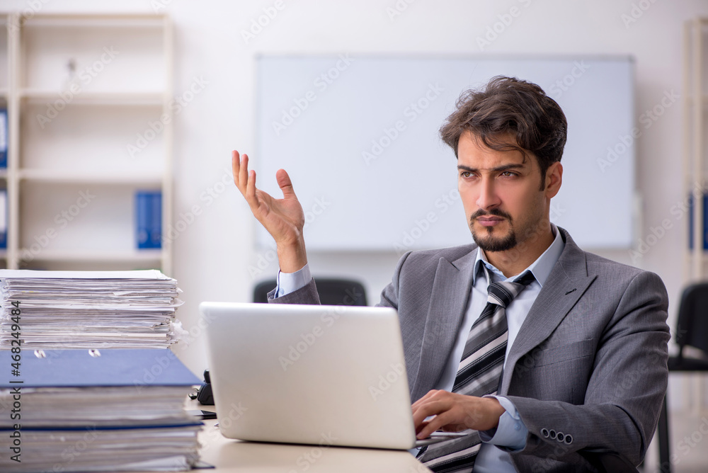 Young businessman employee and too much work in the office Young businessman employee and too much work in the office
