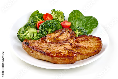 Roasted pork steak with vegetable salad, isolated on white background.