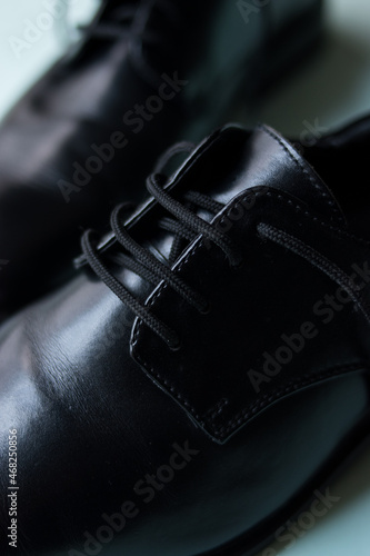 Close up of some fancy black bright shoes on a green surface 