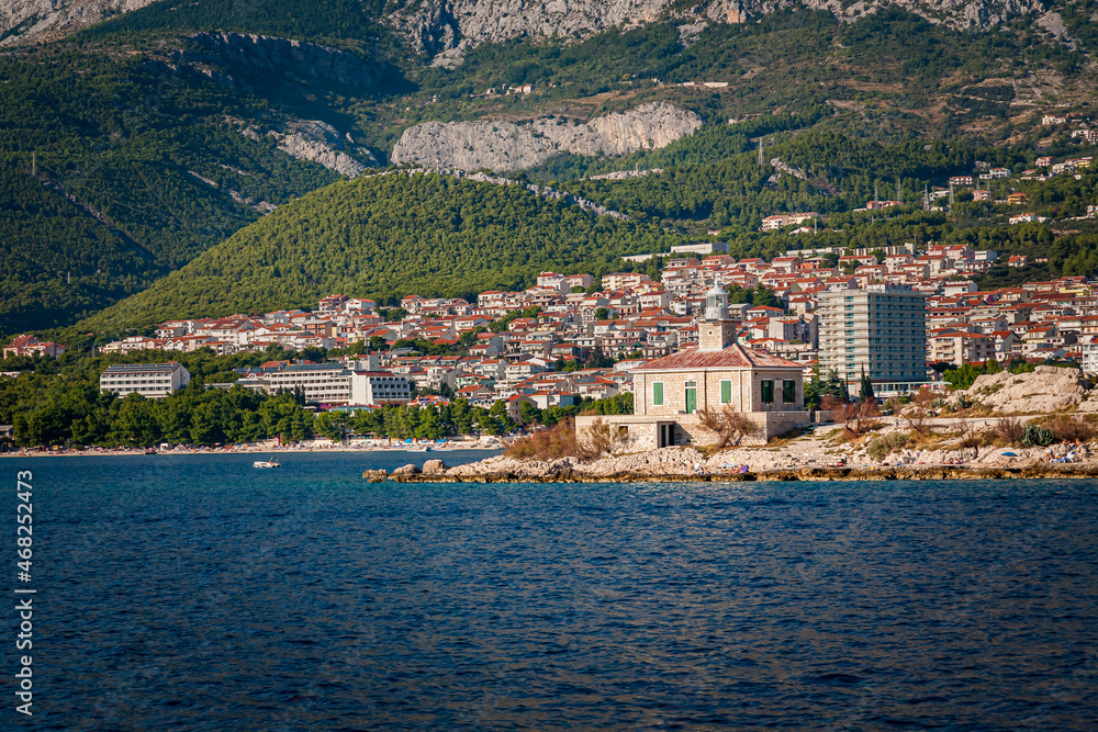 Navigational lighthouse stands in front of the town of Makarska, Croatia