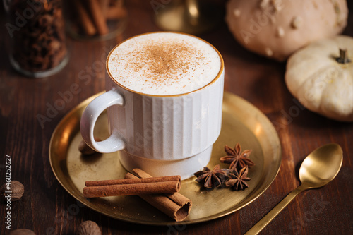A cup of pumpkin spice latte or salep in a rustic wooden autumn atmosphere
