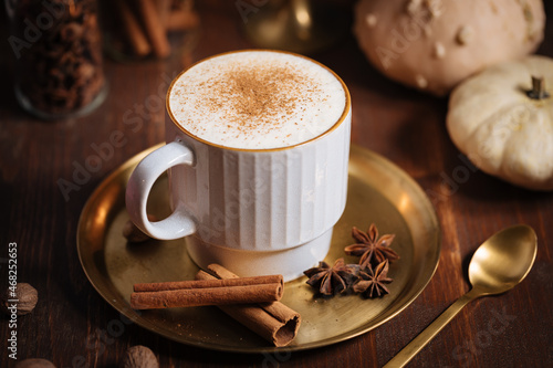 A cup of pumpkin spice latte or salep in a rustic wooden autumn atmosphere