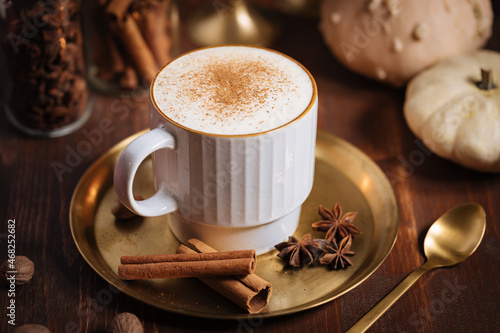 A cup of pumpkin spice latte or salep in a rustic wooden autumn atmosphere photo