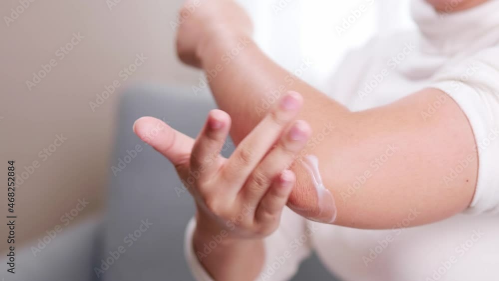 Detail of woman giving pain reliever cream on her elbow due to pain during arm movement. Detail of woman giving pain reliever cream on her elbow due to pain during arm movement.
