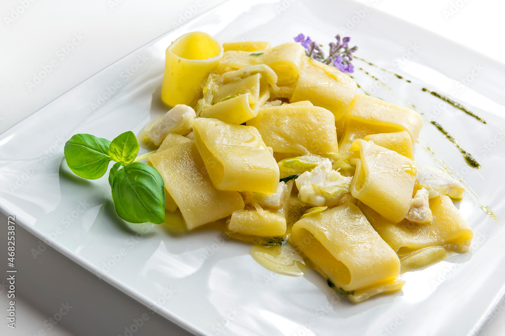 Pasta dish half paccheri with fish ragout and basil sauce Pasta dish half paccheri with fish ragout and basil sauce
