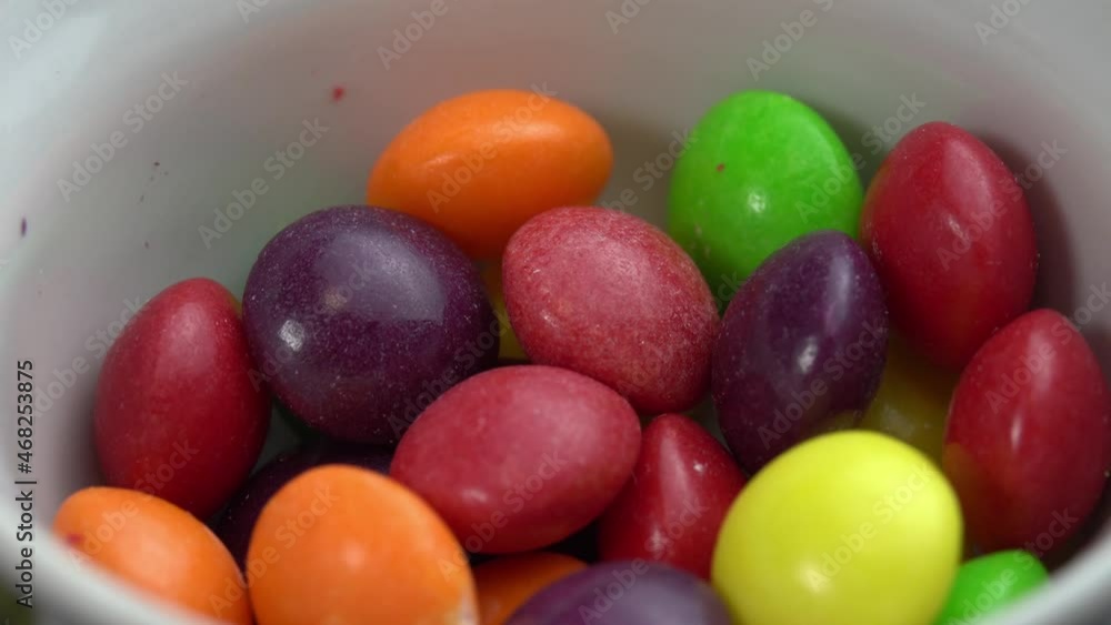 Colored fruit candies rotate on a black background, colored marco sweets Colored fruit candies rotate on a black background, colored marco sweets