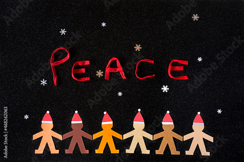 Multiracial human paper chain accompanied by the word PEACE and some snowflakes. Can be used as a greeting card, ... photo