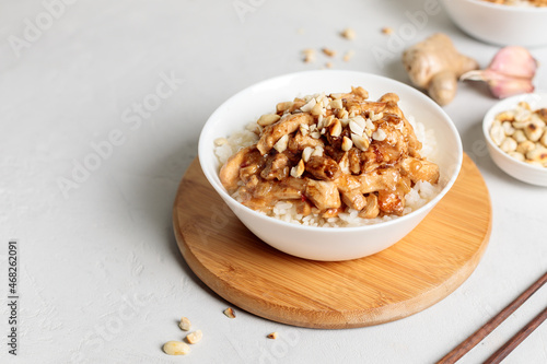 chinese food. Kung pao, rice with chicken fillet in sauce. Close-up on a light background, horizontal