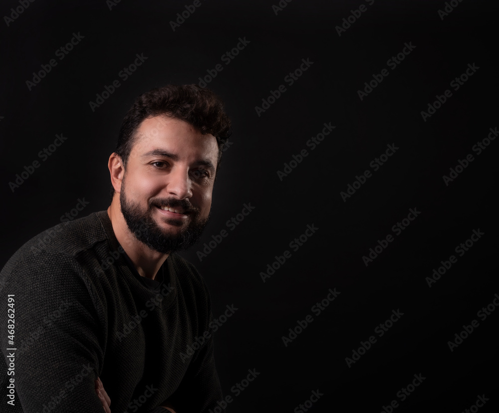 Bearded man in studio shot smiling looking at camera
