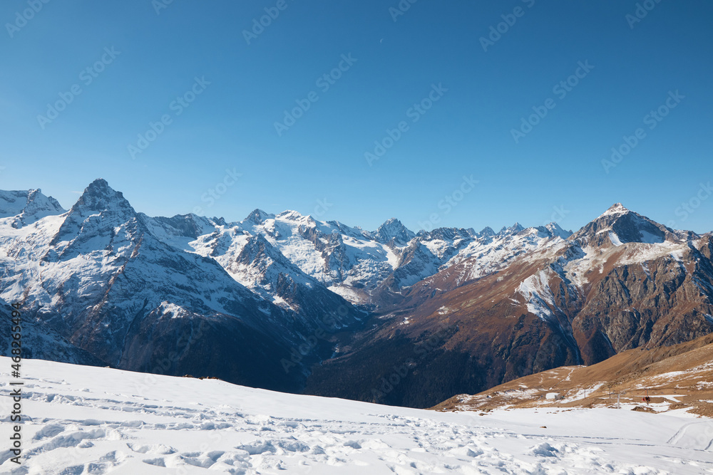 Dombay, alps, snow-covered slopes, the first snow in the mountains, sun and good weather, winter ski season
